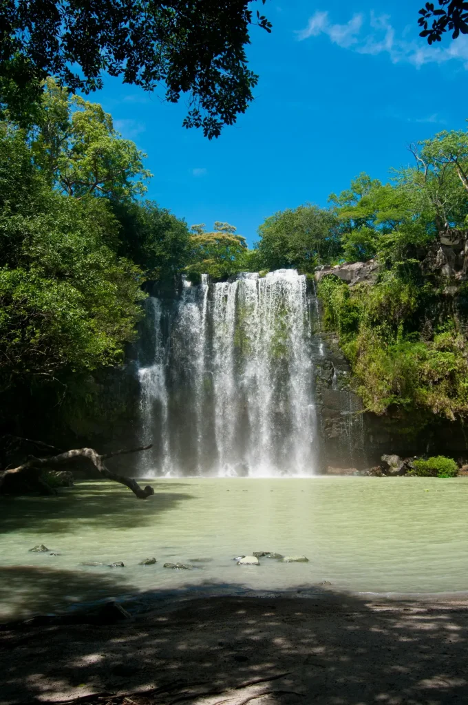 Llanos de Cortés Waterfall flowing into a pool surrounded by trees near Bagaces